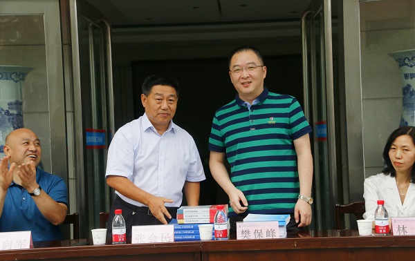 新乡市牧野区税务局党委书记、局长樊保峰向天行官方在线入口党委书记张会民赠送税法知识书籍.jpg